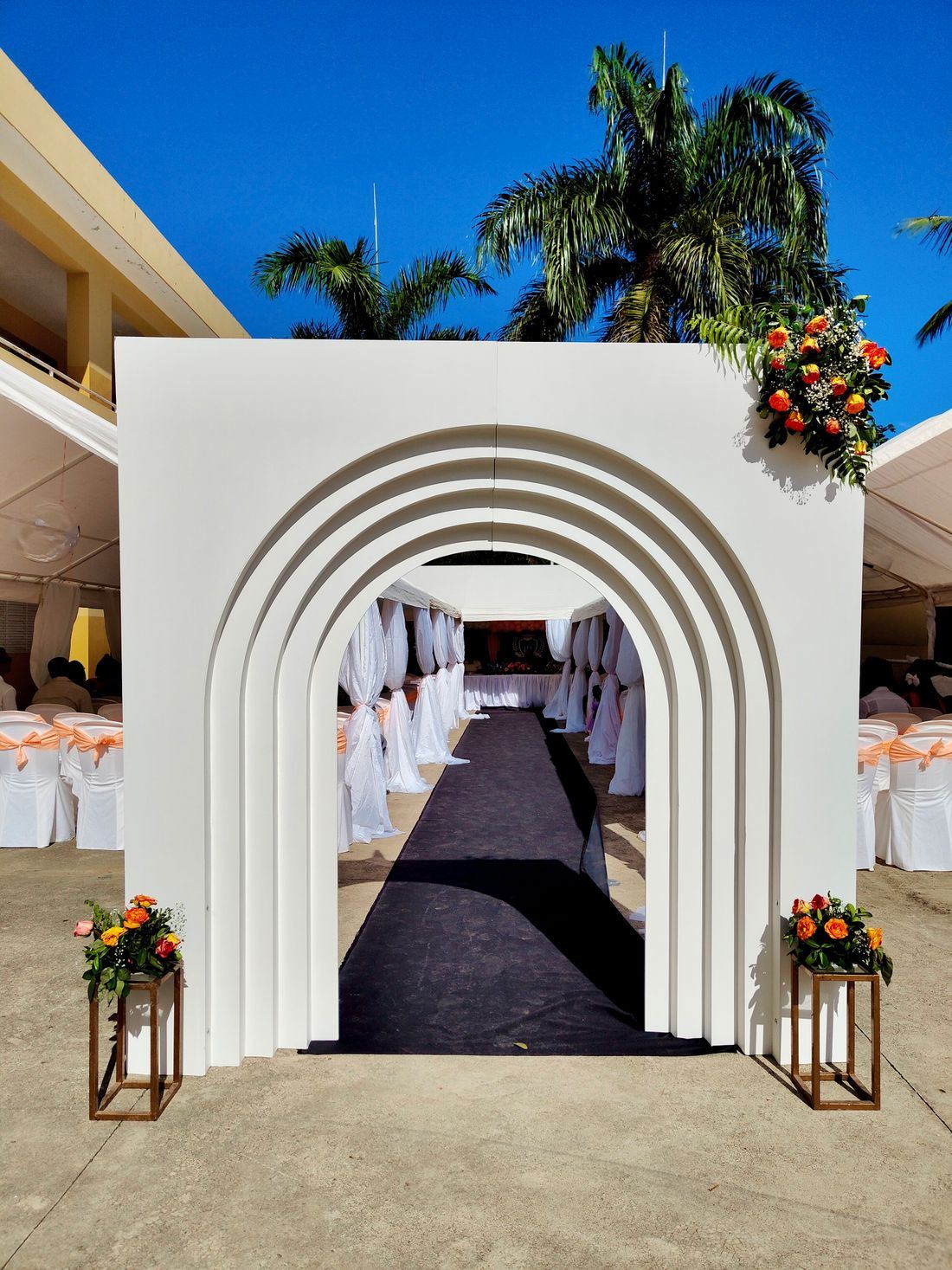 Entrada con arcos blancos y faroles que da paso a un salón de ceremonias